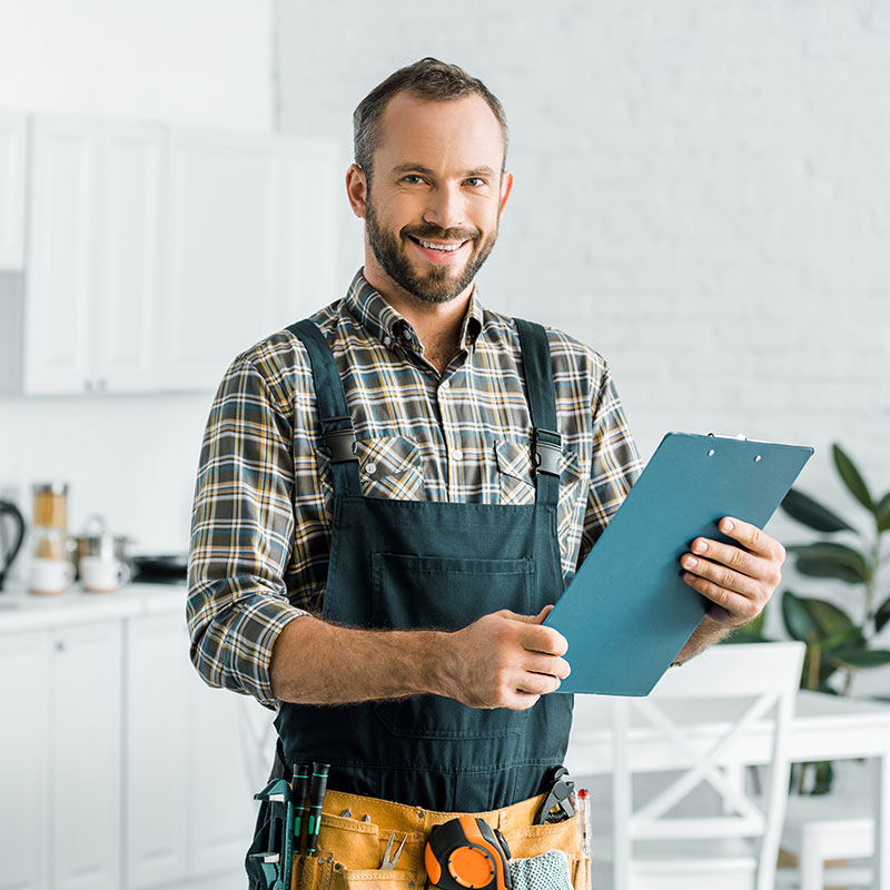 Repairman holding a clipboard; standing in an apartment kitchen